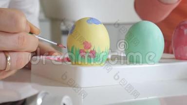 母亲和女儿用彩色颜料画复活节彩蛋